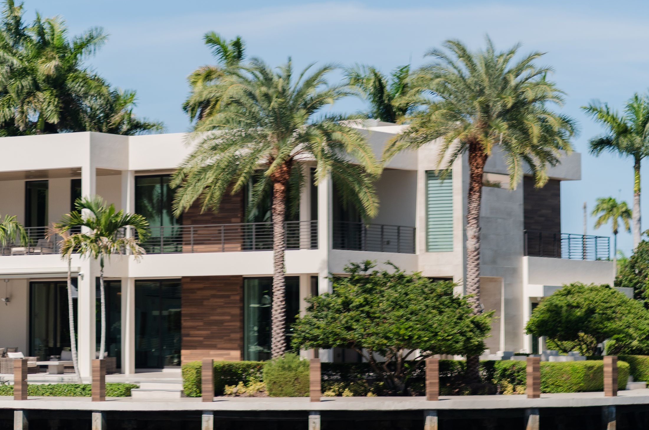 Modern waterfront home with palm trees on a Florida canal